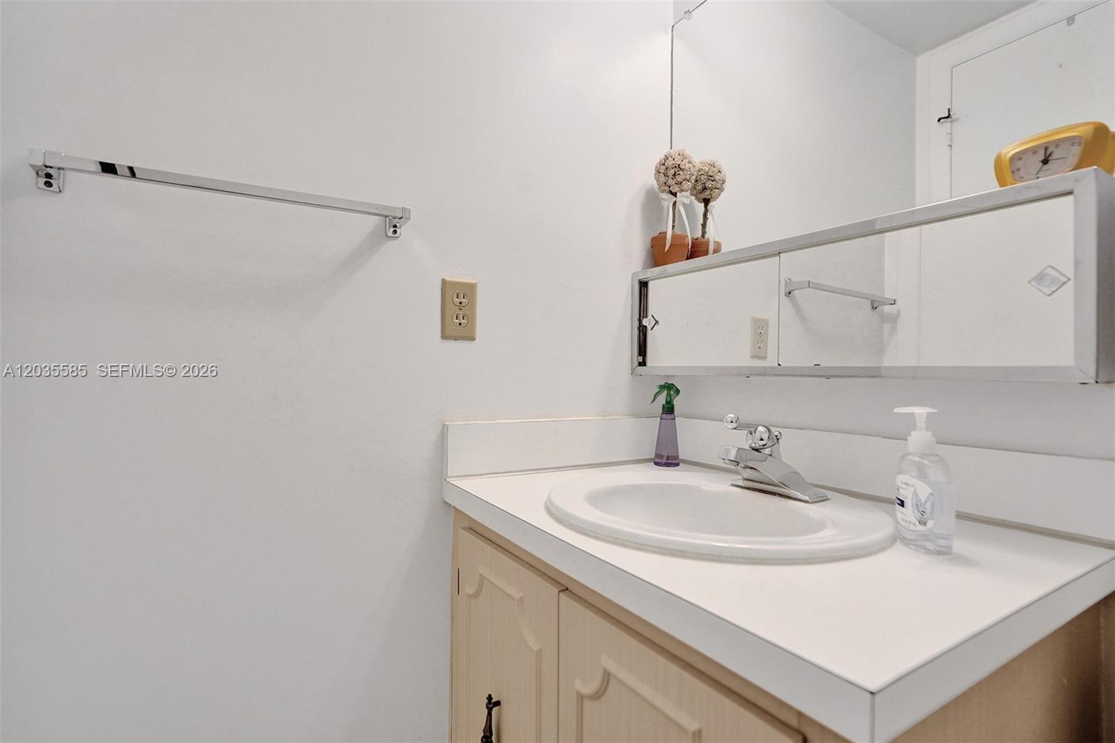 A bathroom vanity features a white countertop, a chrome faucet, and a mirrored medicine cabinet — 3113 S Ocean Dr # 803, Hallandale Beach FL 33009, HALLANDALE BEACH, FL