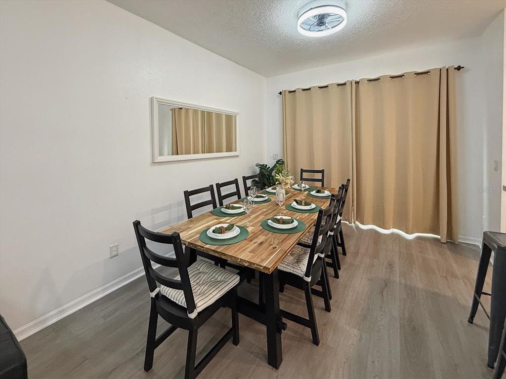 A living room features a grey sectional sofa, a white coffee table, and wall art — 1302 S BEACH CIRCLE, KISSIMMEE, FL