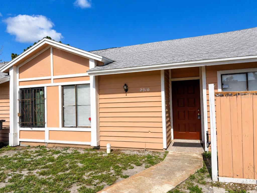 A single-story house with peach-colored horizontal siding, a brown front door, and a gray roof — 2910 WESTERN WILLOW TERRACE, ORLANDO, FL