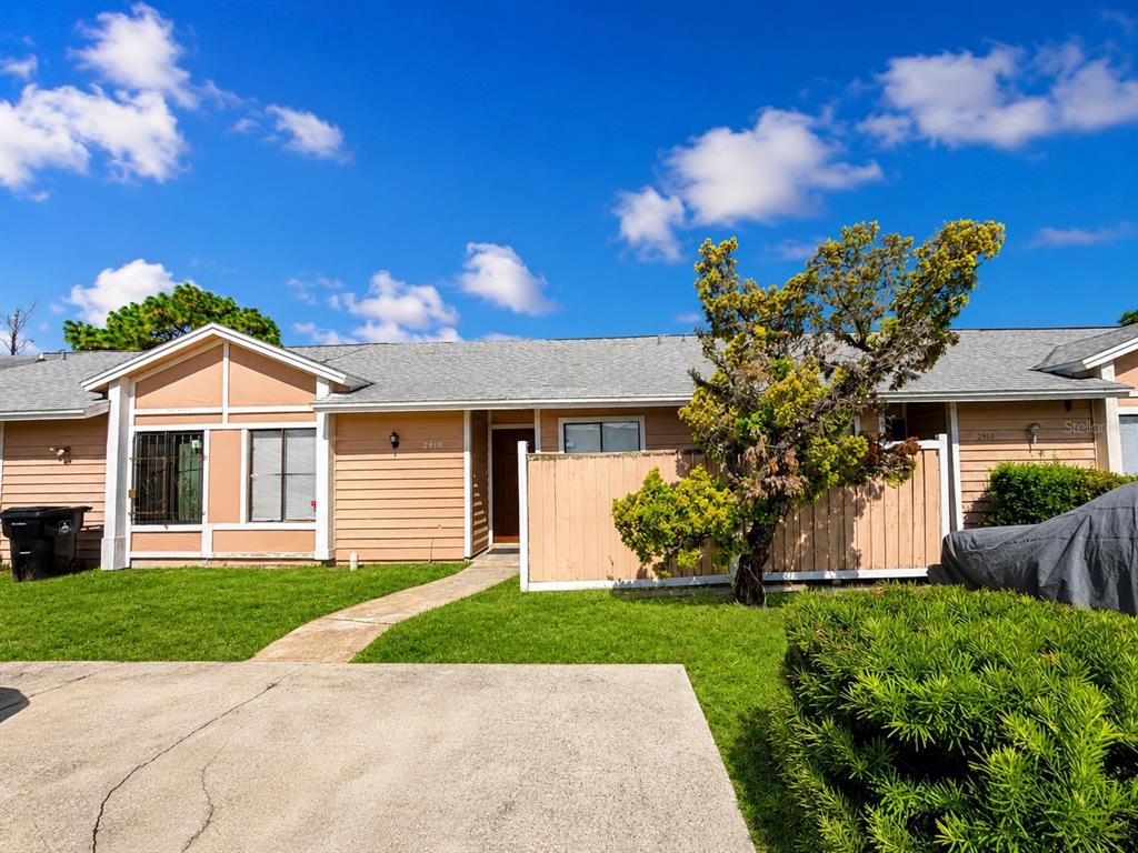 A single-story residential building with tan siding, a concrete driveway, and a small front yard — 2910 WESTERN WILLOW TERRACE, ORLANDO, FL