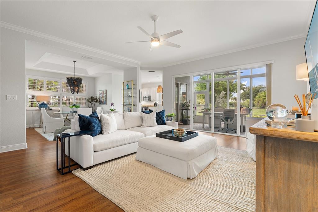 A bright living room features a white sectional sofa, ottoman, and sliding glass patio doors — 197 TROPICANA DRIVE UNIT 1511, PUNTA GORDA, FL