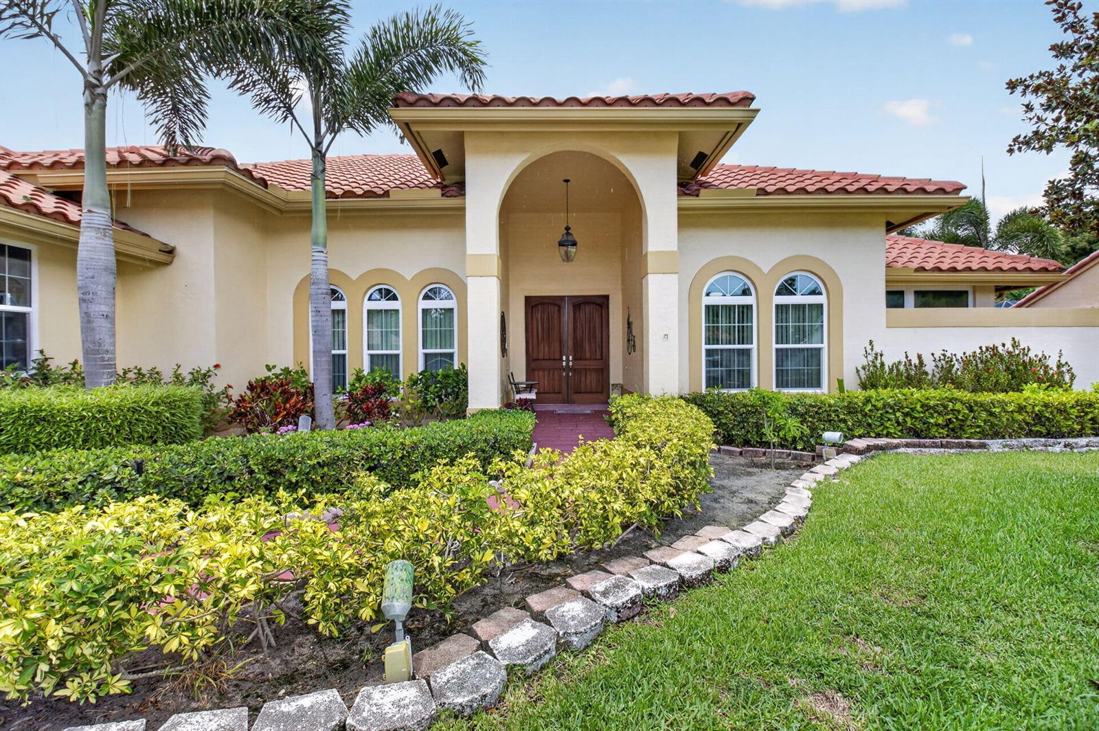 A single-story house with a stucco exterior, tile roof, arched entryway, and landscaped front yard — 2931 NW 25th Way, Boca Raton FL 33434, BOCA RATON, FL