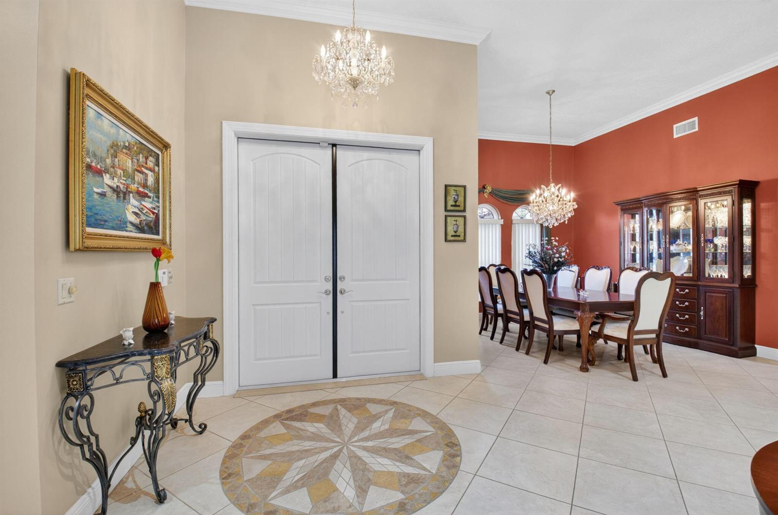 A foyer with a tile medallion floor leads into a formal dining room with red walls — 2931 NW 25th Way, Boca Raton FL 33434, BOCA RATON, FL