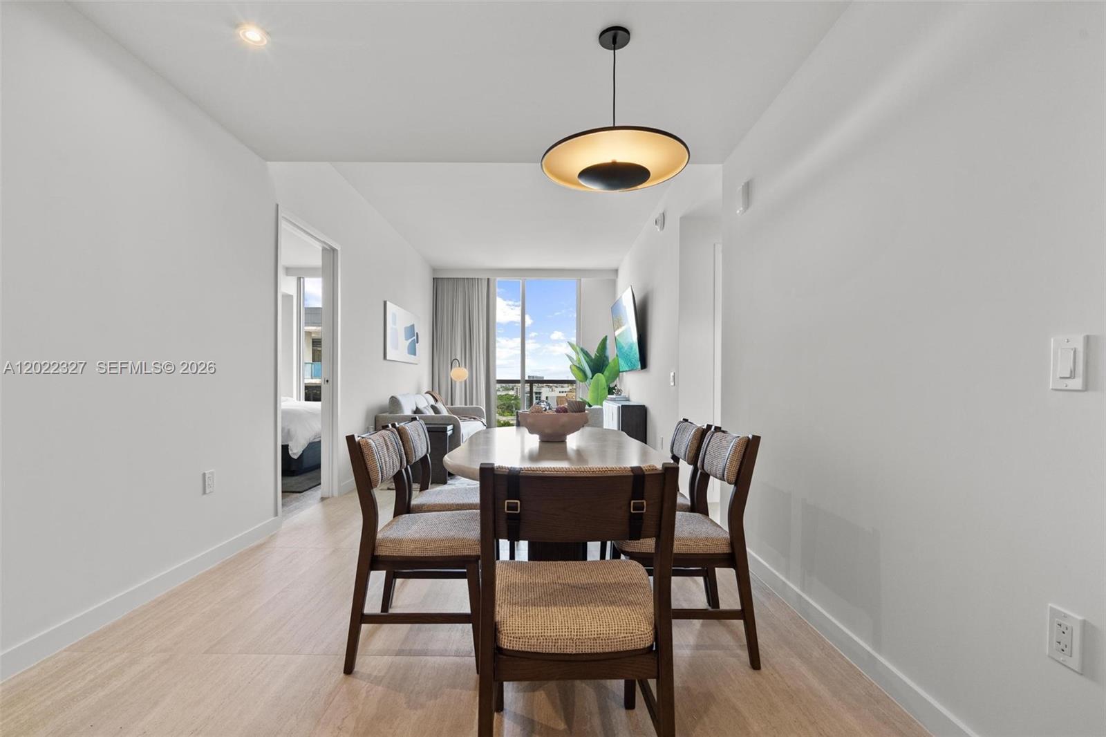 A dining area with a wooden table and chairs leads to a living room — 1611 SW 2nd Ave # 817, Miami FL 33129, MIAMI, FL