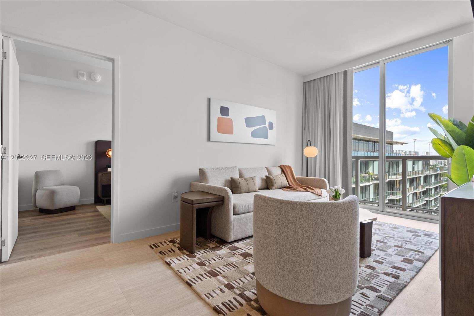 A living room features a sofa, accent chair, area rug, and a balcony with views — 1611 SW 2nd Ave # 817, Miami FL 33129, MIAMI, FL