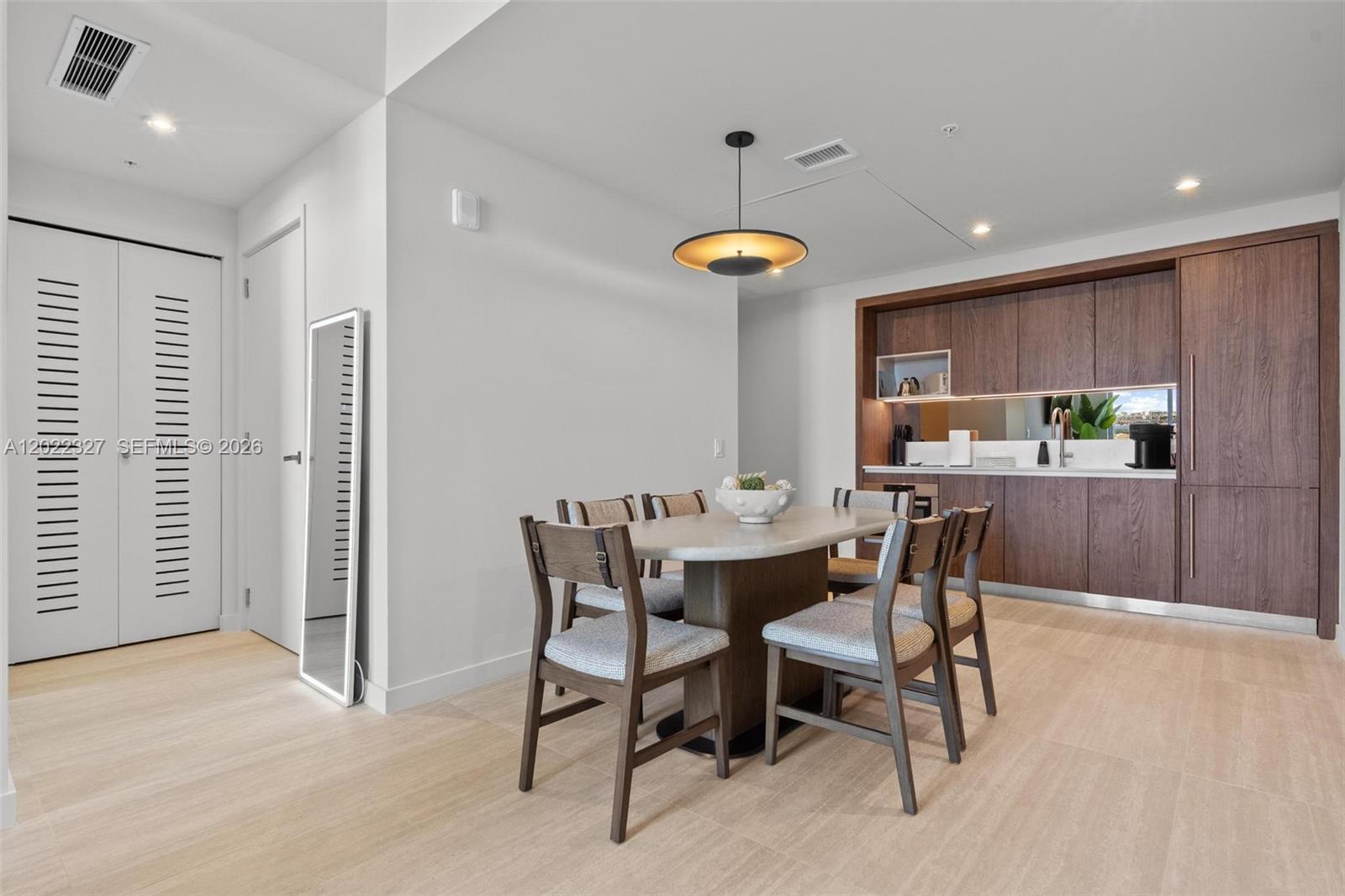 A dining area features a stone-topped table, wooden chairs, and a built-in wet bar — 1611 SW 2nd Ave # 817, Miami FL 33129, MIAMI, FL