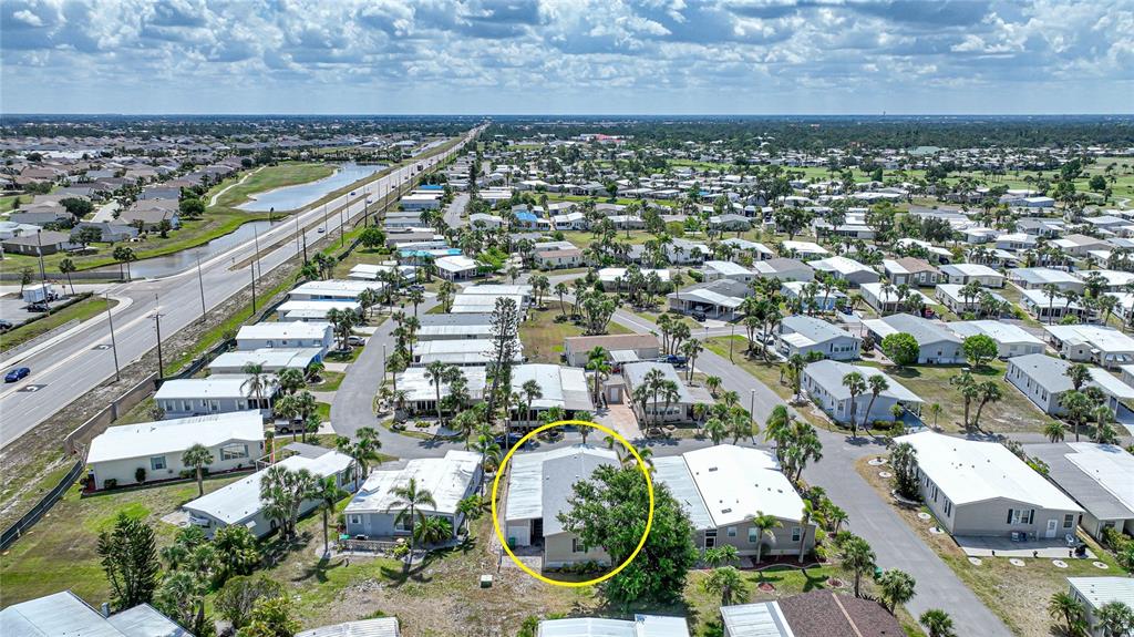 An aerial view shows a mobile home community with a yellow circle highlighting one house — 2100 KINGS HWY UNIT 206, PORT CHARLOTTE, FL