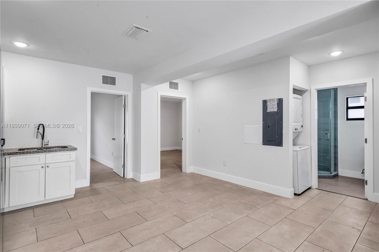 A room with tile flooring, a small kitchenette, two doorways, and a laundry closet — 1749 NW 64th St # A, Miami FL 33147, MIAMI, FL