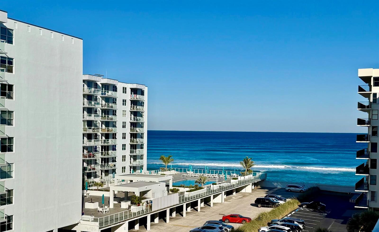 An elevated view of a beachside resort with a pool, parking lot, and ocean — 3460 S Ocean Boulevard # 5110, Palm Beach FL 33480, PALM BEACH, FL