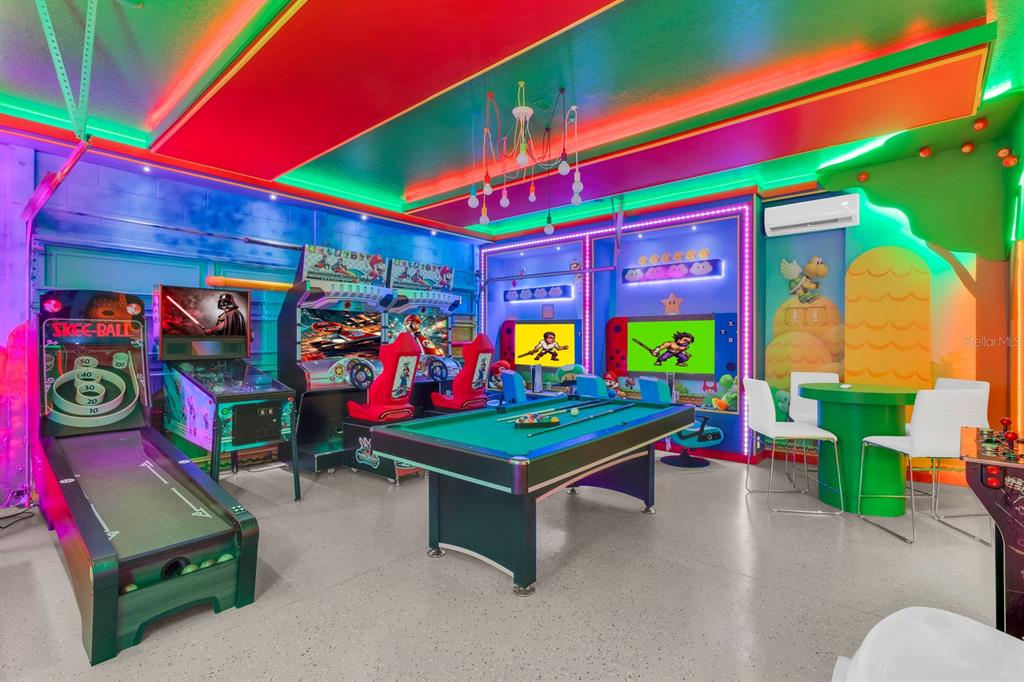 A vibrant, neon-lit game room featuring a pool table, arcade machines, and Mario-themed decor — 7568 MARKER AVENUE, KISSIMMEE, FL