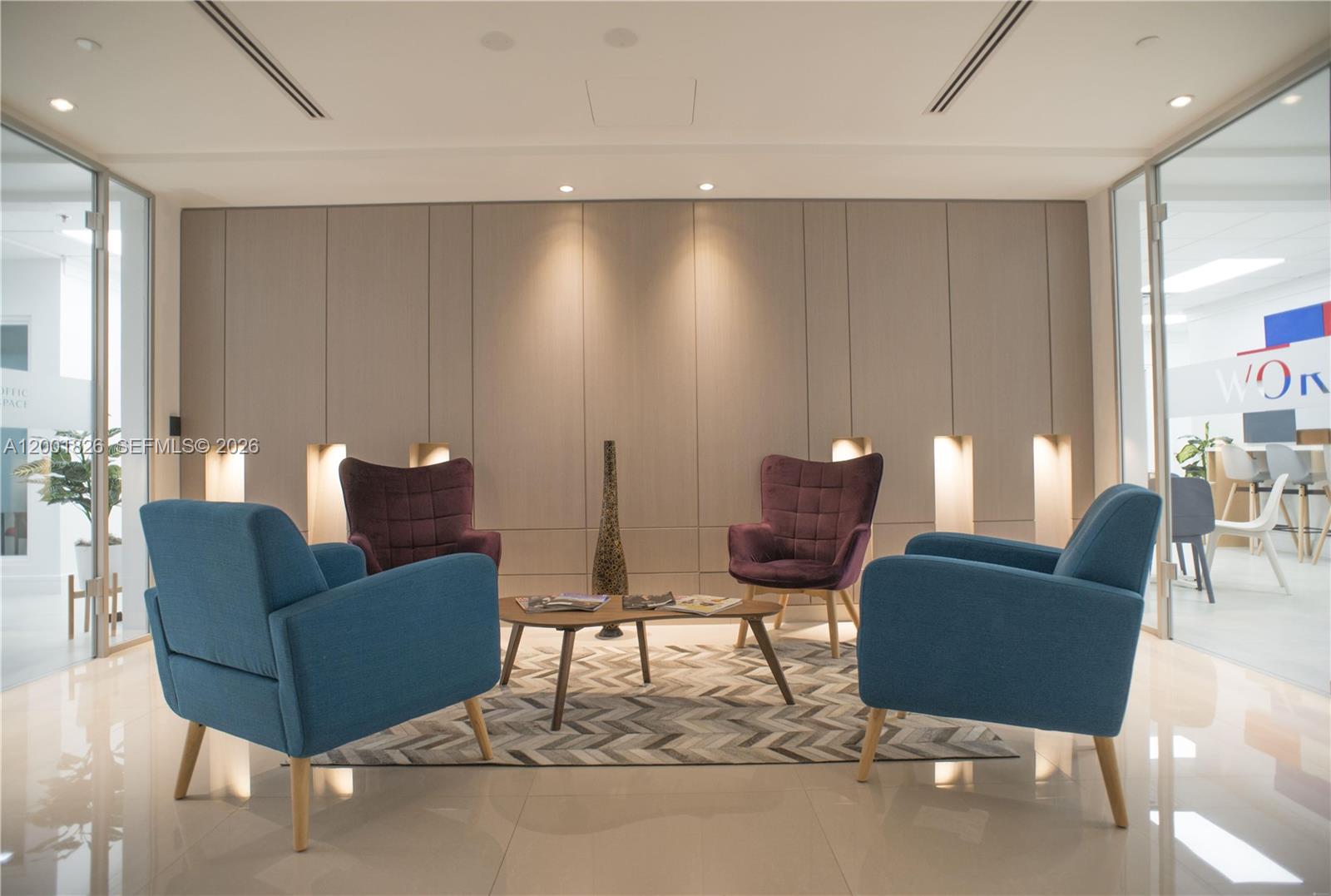 A modern office waiting area features four armchairs, a coffee table, and wood-paneled walls — 1000 Brickell Ave # 11A, Miami FL 33131, MIAMI, FL