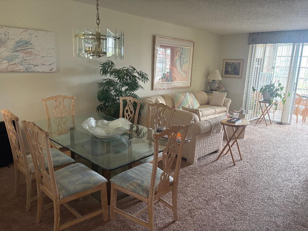 A dining area with a glass table and chairs adjacent to a living room sofa — 7301 NW 1st Street # 406, Margate FL 33063, MARGATE, FL