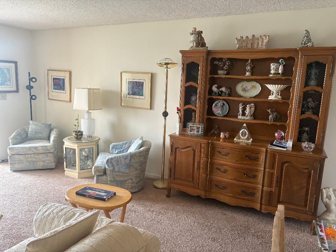 A living room features a wooden hutch, two patterned armchairs, and a small coffee table — 7301 NW 1st Street # 406, Margate FL 33063, MARGATE, FL