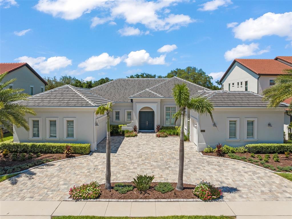 A single-story house with a paved driveway, two palm trees, and a tiled roof — 15619 GIANT FOXTAIL COURT, WINTER GARDEN, FL