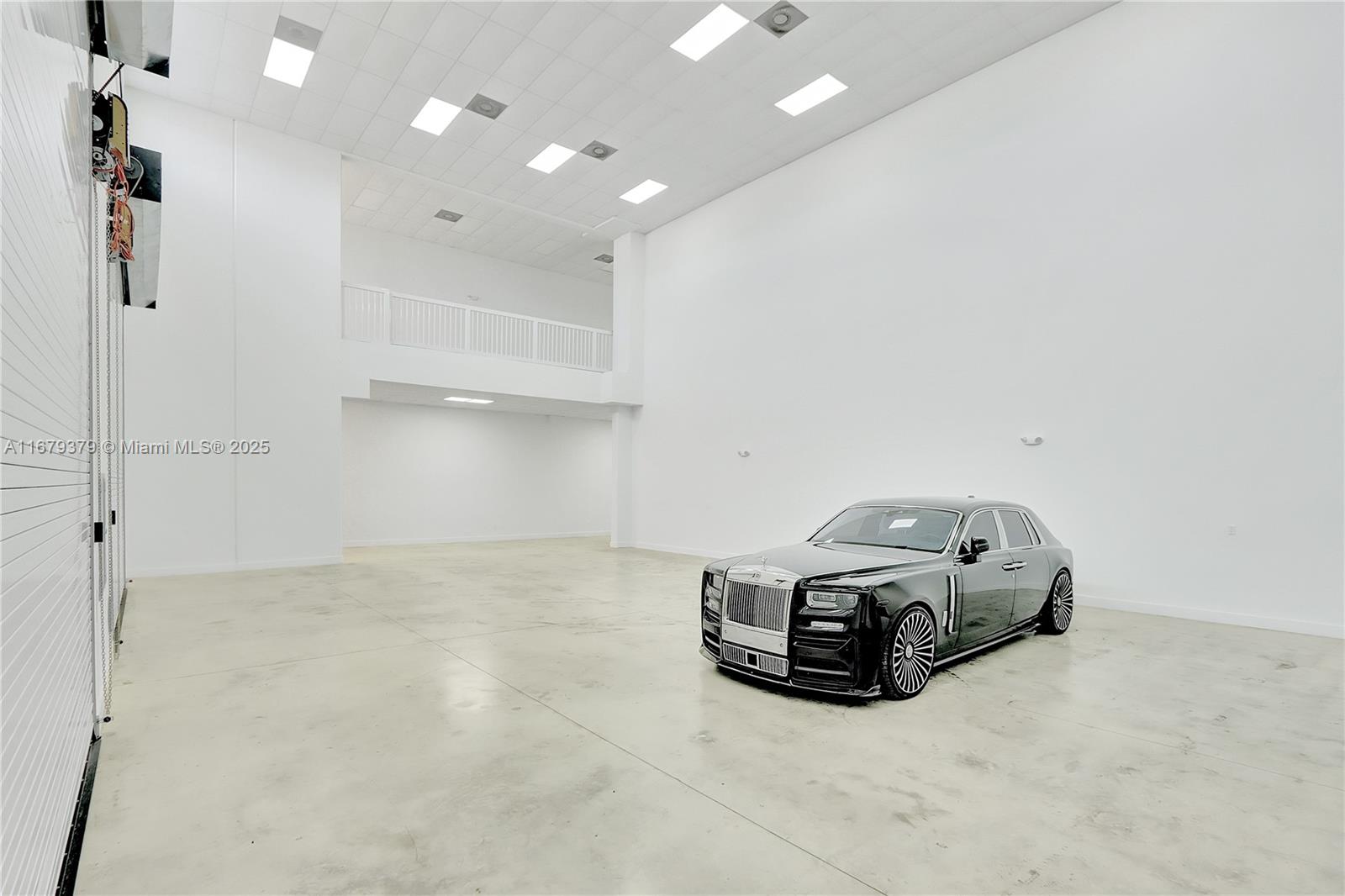 A black Rolls-Royce is parked inside a large, white-walled industrial warehouse space — 6700 NE 2nd Ct # 4, Miami FL 33138, MIAMI, FL