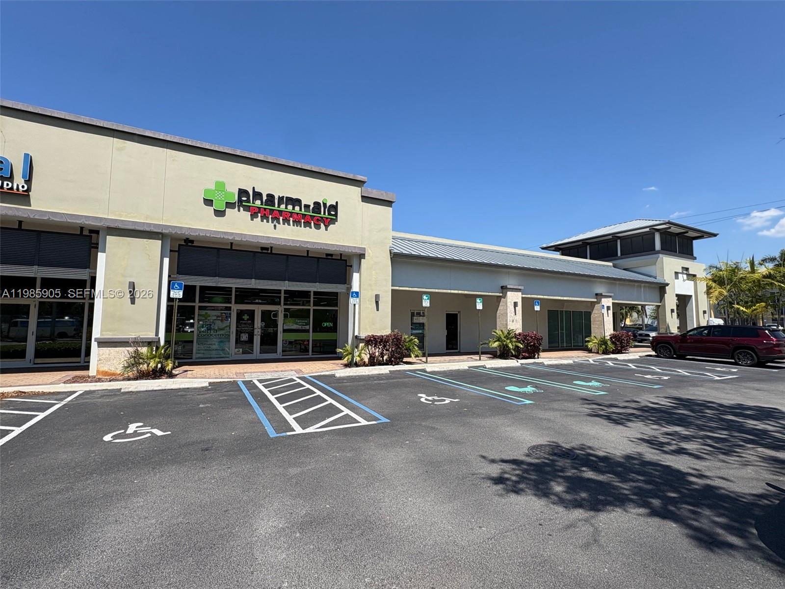 A commercial strip mall building features a pharmacy storefront and designated handicap parking spaces — 2100 NW 107th Ave, Doral FL 33172, DORAL, FL