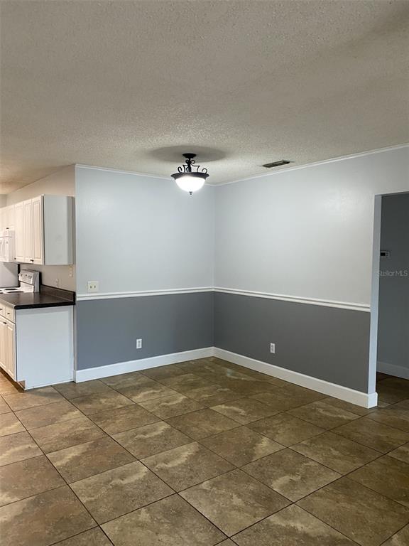 A dining area features two-tone gray and white walls, a light fixture, and tiled flooring — 12310 TAVARES RIDGE COURT UNIT 144, TAVARES, FL