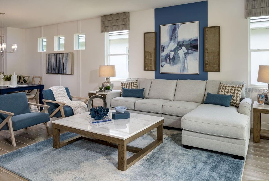 A living room features a light gray sectional sofa, blue accent chairs, and a marble coffee table — 2366 WISE RIVER LANE, ZEPHYRHILLS, FL