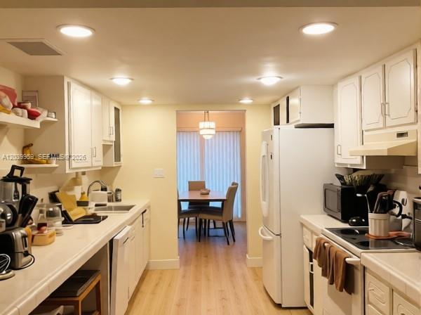 A kitchen with white cabinets, light countertops, and a view into a dining area — 2800 S University Dr # 0, Davie FL 33328, DAVIE, FL
