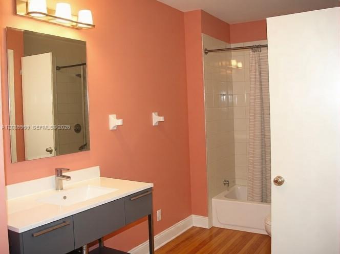 A bathroom features a gray vanity, a mirror, and a shower-tub combination with peach walls — 2800 S University Dr # 0, Davie FL 33328, DAVIE, FL