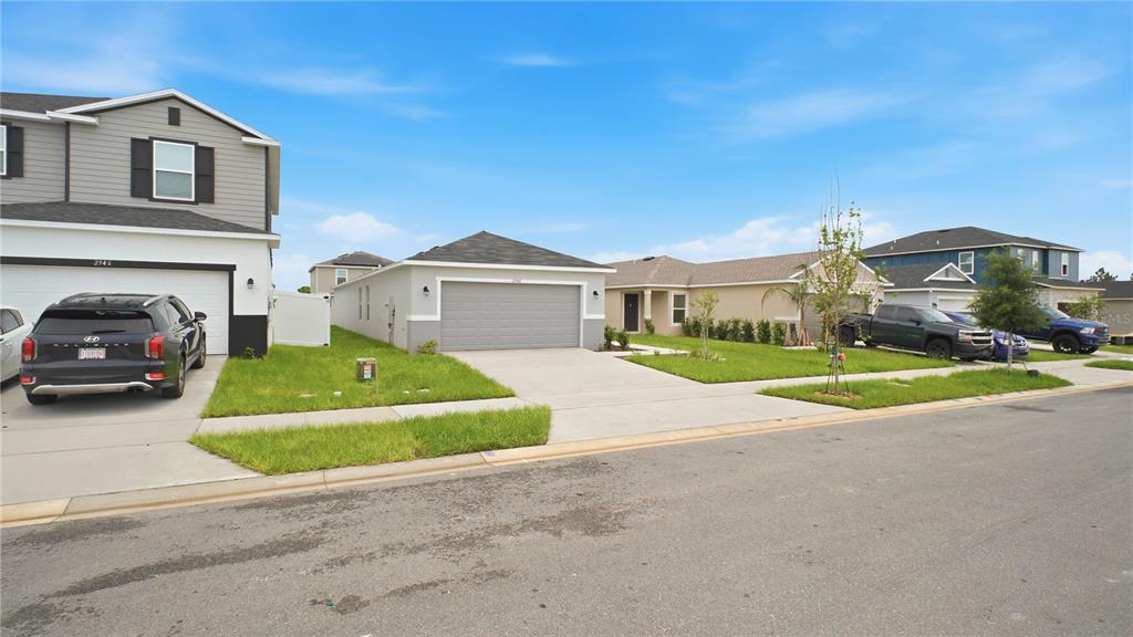 A street view of several modern suburban houses with driveways and manicured lawns — 2942 LAVANDA DRIVE, HAINES CITY, FL