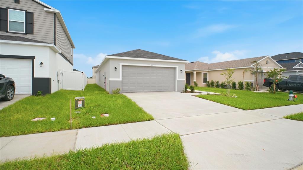 A single-story house with a gray garage and a concrete driveway in a suburban neighborhood — 2942 LAVANDA DRIVE, HAINES CITY, FL