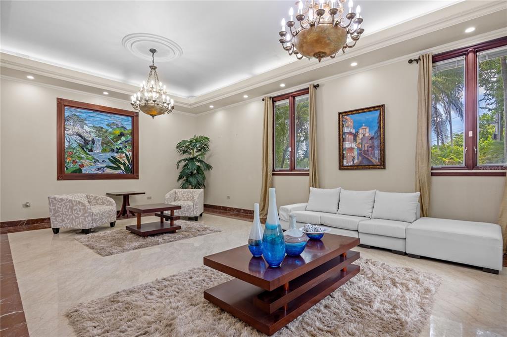 A spacious living room features marble floors, two chandeliers, a white sectional, and wall art — 17 Calle Durazno URBANIZACION SAN PATRICIO, GUAYNABO, PR