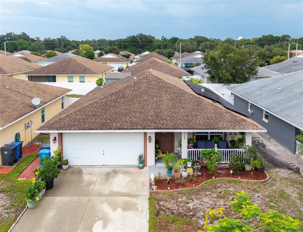 An aerial view of a single-story house with a brown shingled roof and garage — 1128 SHARED PASSION ST, RUSKIN, FL