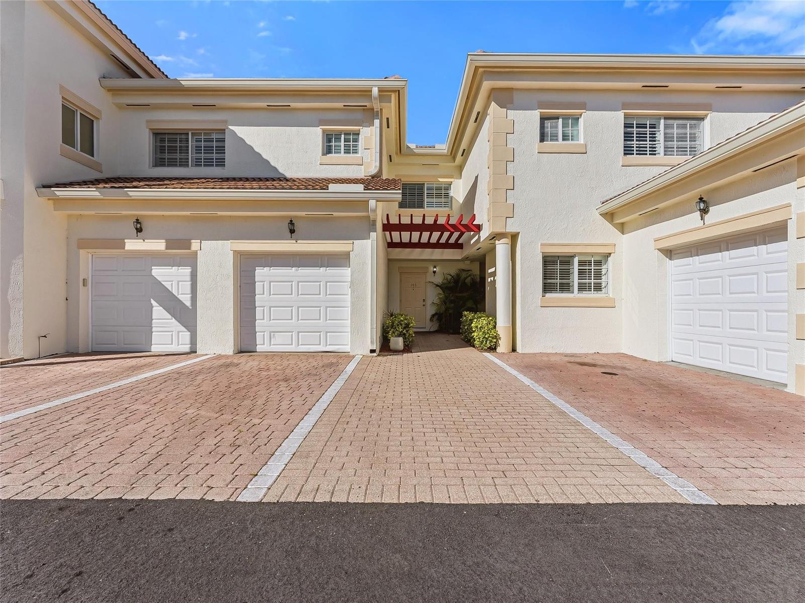 A two-story residential building features three garage doors and a central recessed entryway — 504 7th Square # 103, Vero Beach FL 32962, VERO BEACH, FL