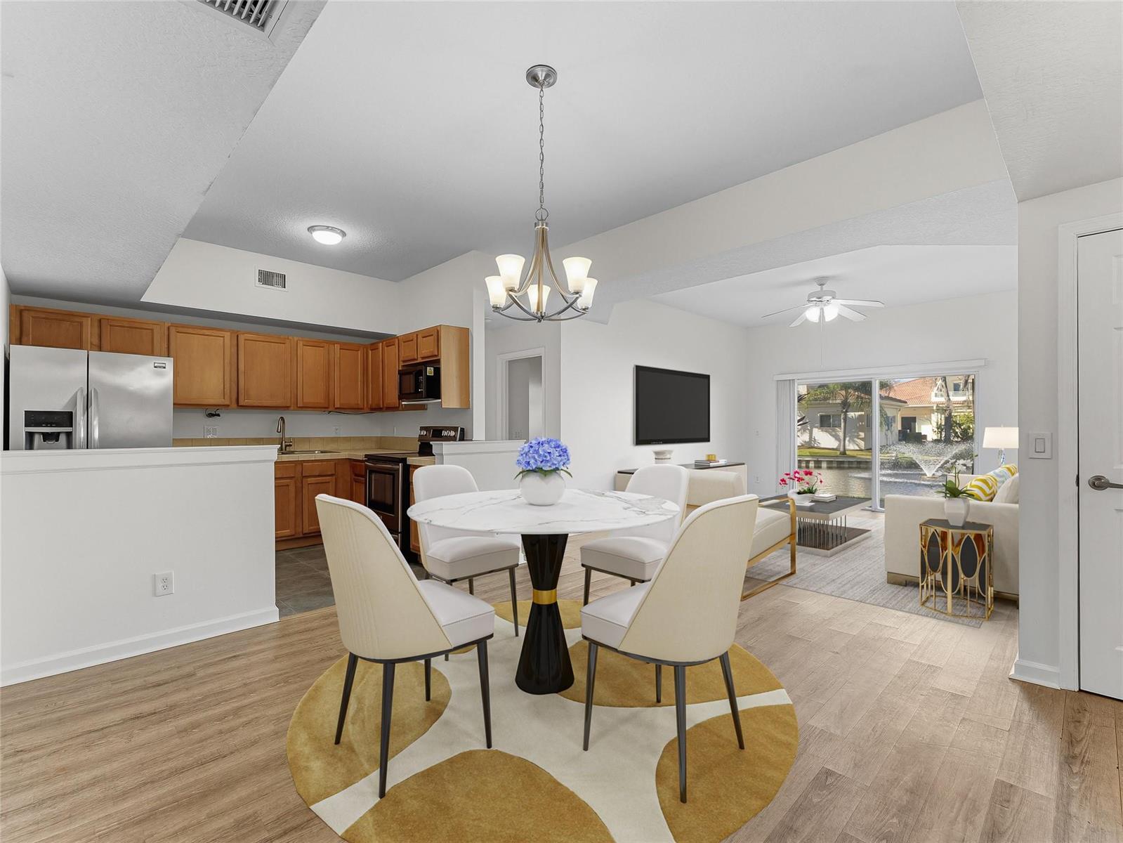 A dining area with a round table and chairs opens into a kitchen and living room — 504 7th Square # 103, Vero Beach FL 32962, VERO BEACH, FL