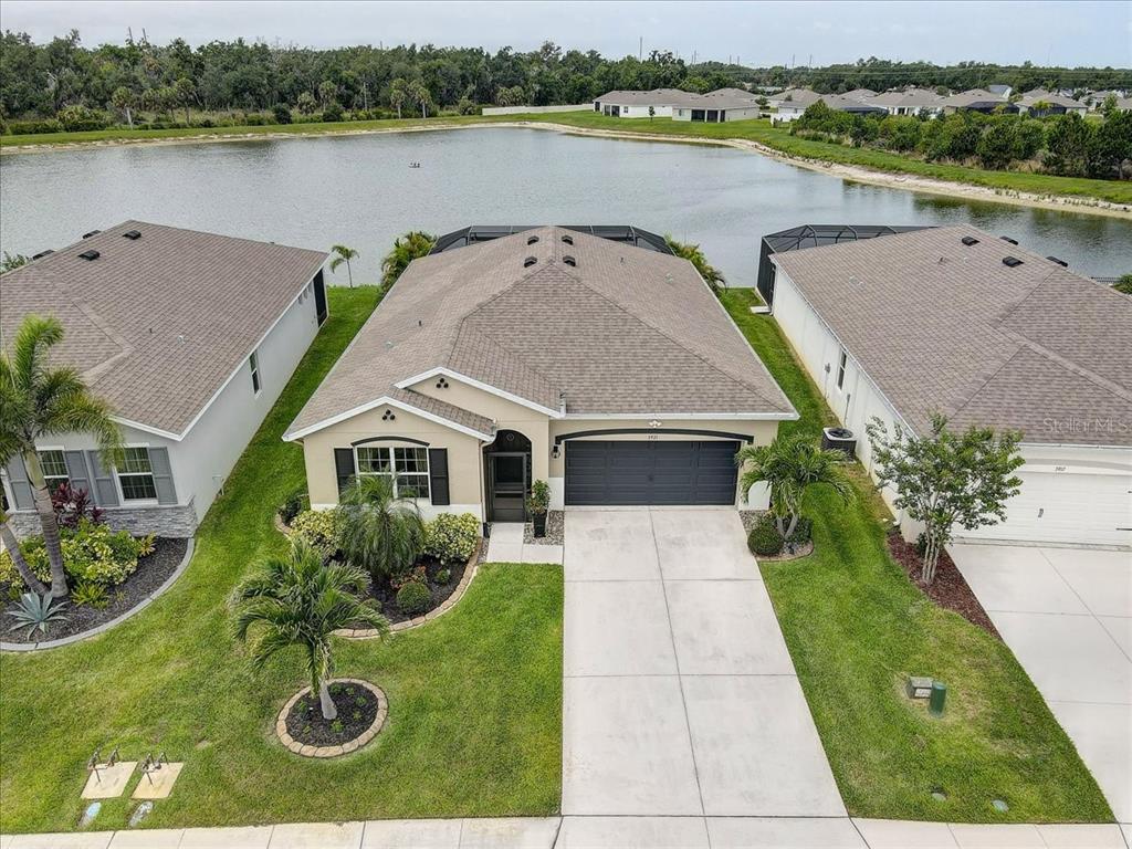 An aerial view of a single-story suburban house with a driveway and a backyard pond — 3921 MOSSY LIMB COURT, PALMETTO, FL