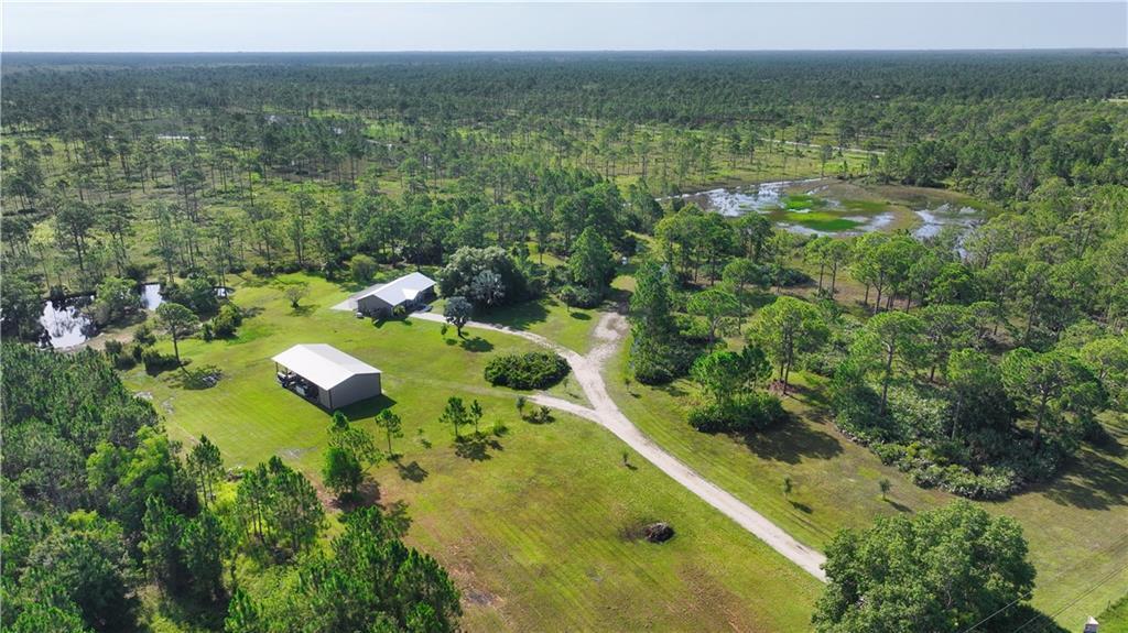 An aerial view shows a house and a detached garage on a large, wooded rural lot — 12050 138th Avenue, Fellsmere FL 32948, FELLSMERE, FL
