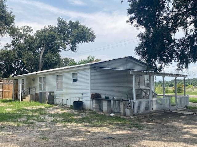 A single-story mobile home with white siding and a covered front porch sits on a lot — 10838 MAIN STREET, THONOTOSASSA, FL