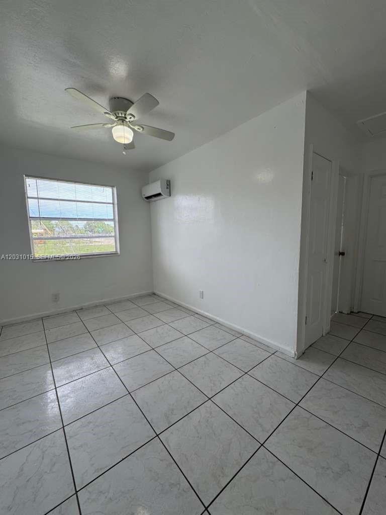 A room with white walls, tiled flooring, a ceiling fan, and a window — FORT LAUDERDALE, FL