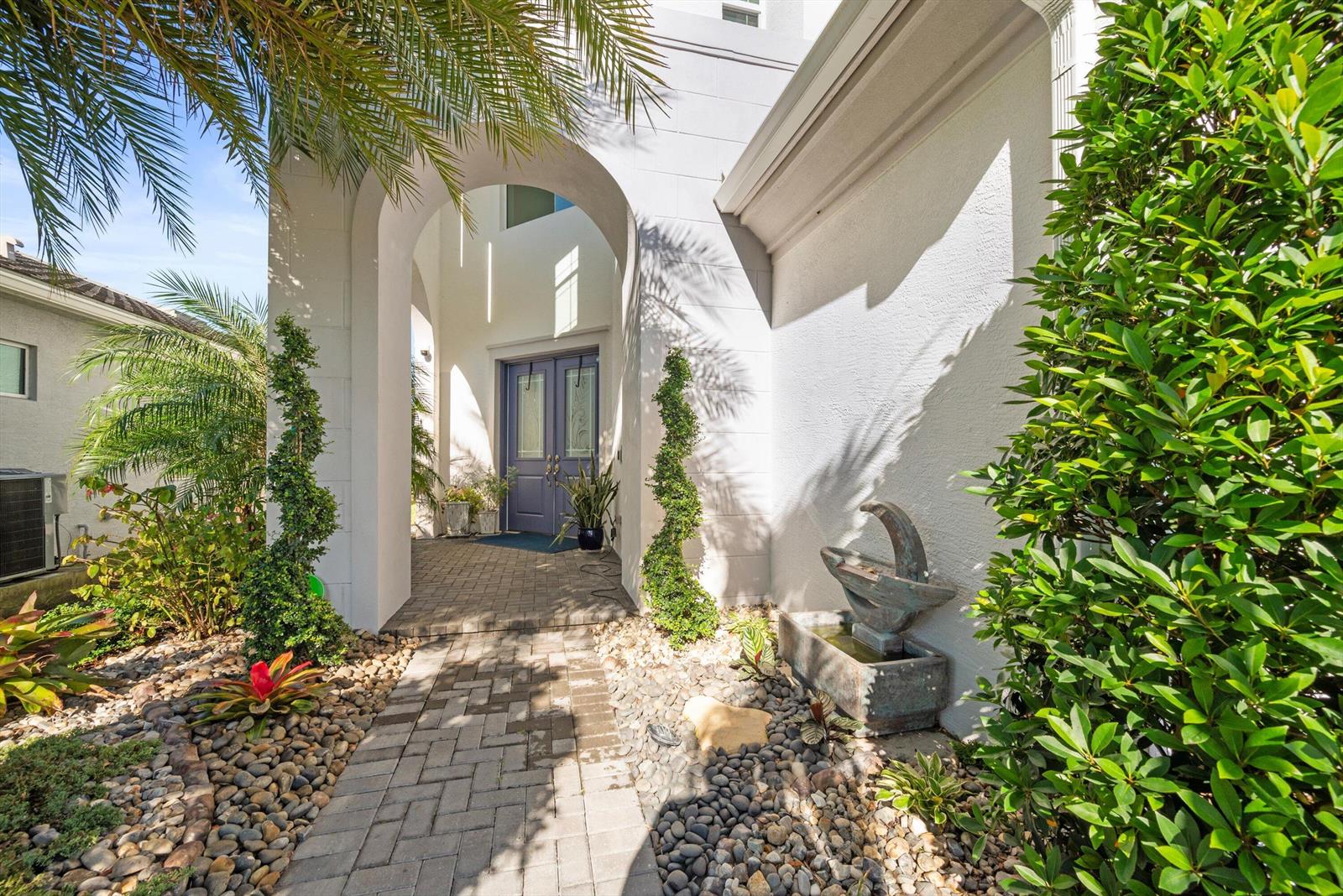 A paved walkway leads to a covered entryway with a purple double door — 4619 Citron Way, Westlake FL 33470, WESTLAKE, FL