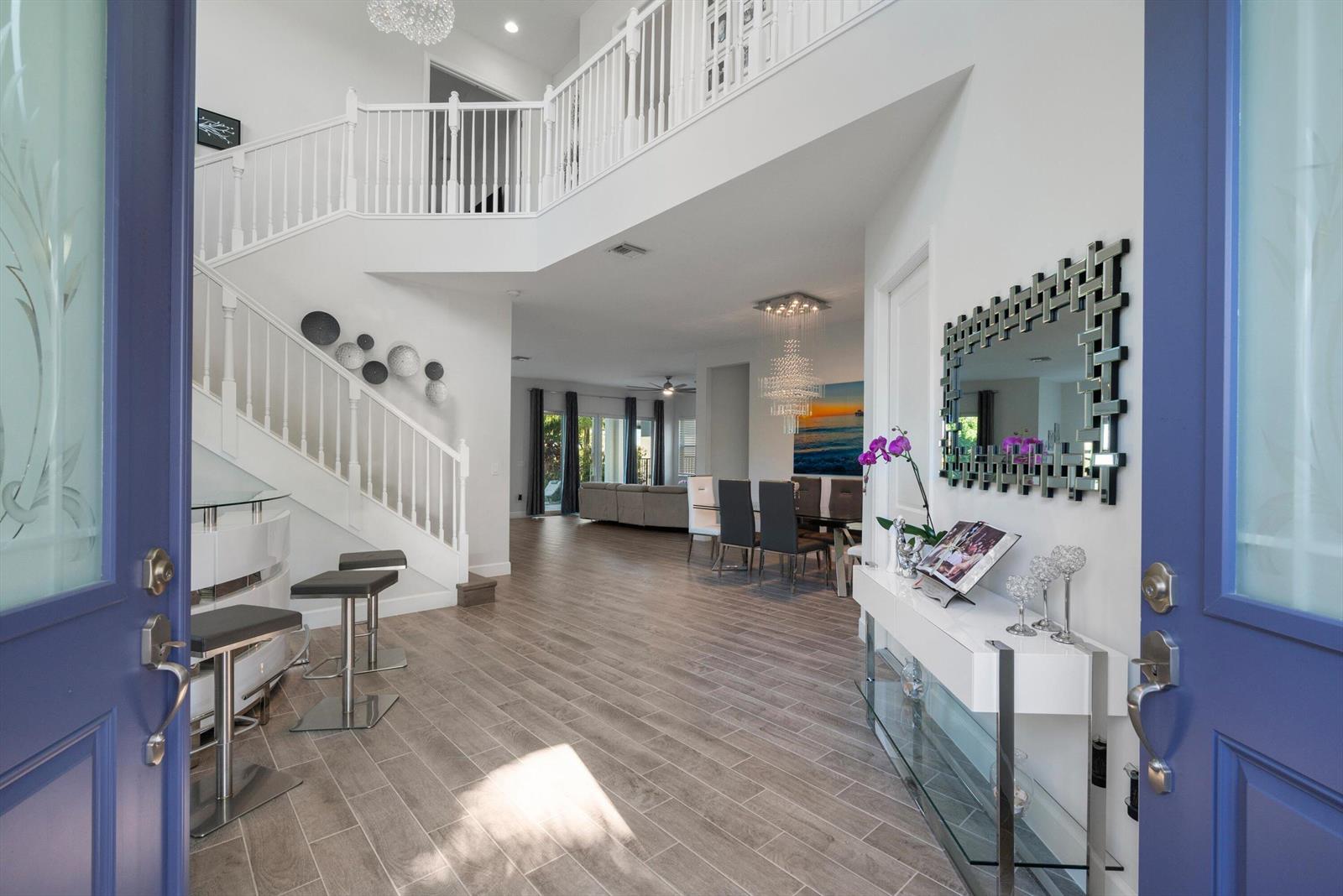 An entryway with a staircase, tile flooring, and a view into the dining area — 4619 Citron Way, Westlake FL 33470, WESTLAKE, FL