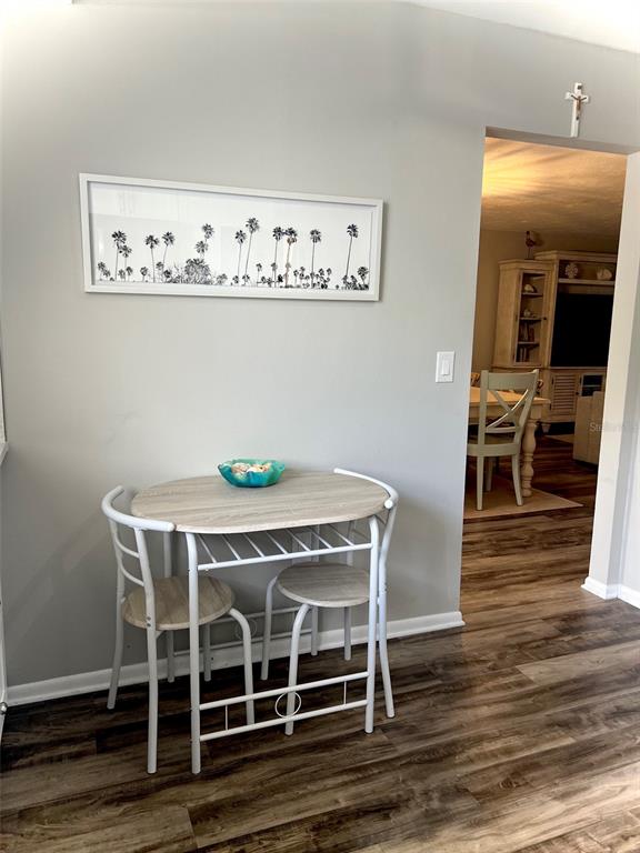A small dining set with two chairs sits against a gray wall under framed art — 5110 MARSH FIELD ROAD UNIT 68, SARASOTA, FL