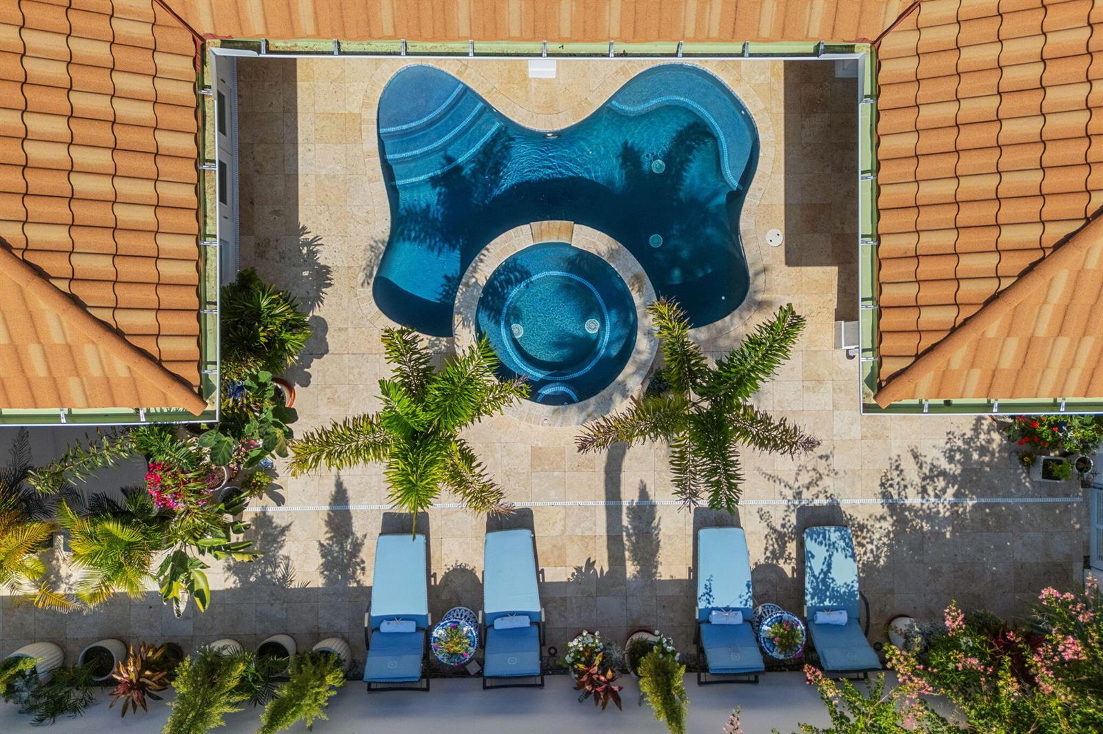 An aerial view shows a courtyard with a swimming pool, hot tub, and four lounge chairs — 906 Jasmine Lane, Vero Beach FL 32963, VERO BEACH, FL