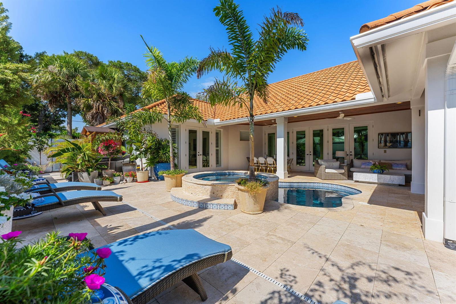 A patio features a small pool, a raised hot tub, palm trees, and lounge chairs — 906 Jasmine Lane, Vero Beach FL 32963, VERO BEACH, FL