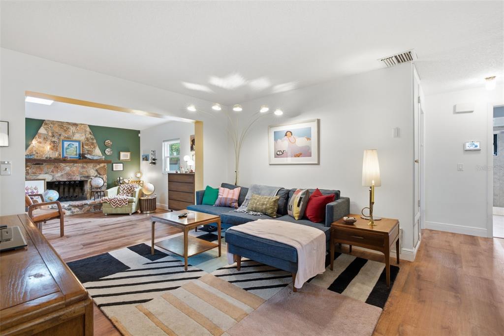 A living room features a blue sectional sofa, a stone fireplace, and a geometric area rug — 530 E FOOTHILL WAY, CASSELBERRY, FL