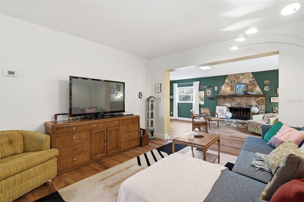 A living room features a television on a wooden dresser, a sofa, and a fireplace — 530 E FOOTHILL WAY, CASSELBERRY, FL