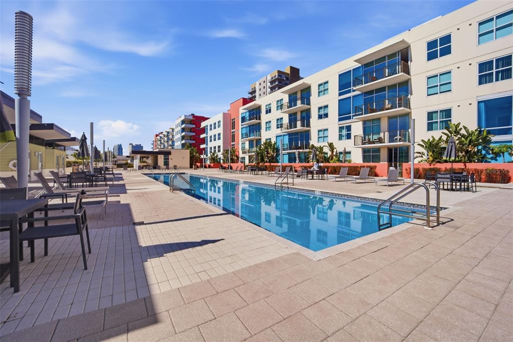 A rectangular swimming pool sits on a paved deck surrounded by modern multi-story apartment buildings — 1208 E KENNEDY BOULEVARD UNIT 1121, TAMPA, FL
