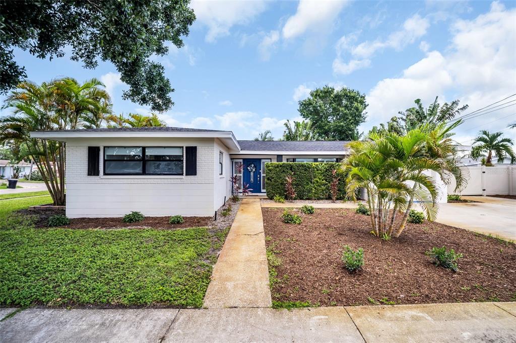 A single-story white house with a blue front door and a palm tree in front — 3361 59TH STREET N, ST PETERSBURG, FL