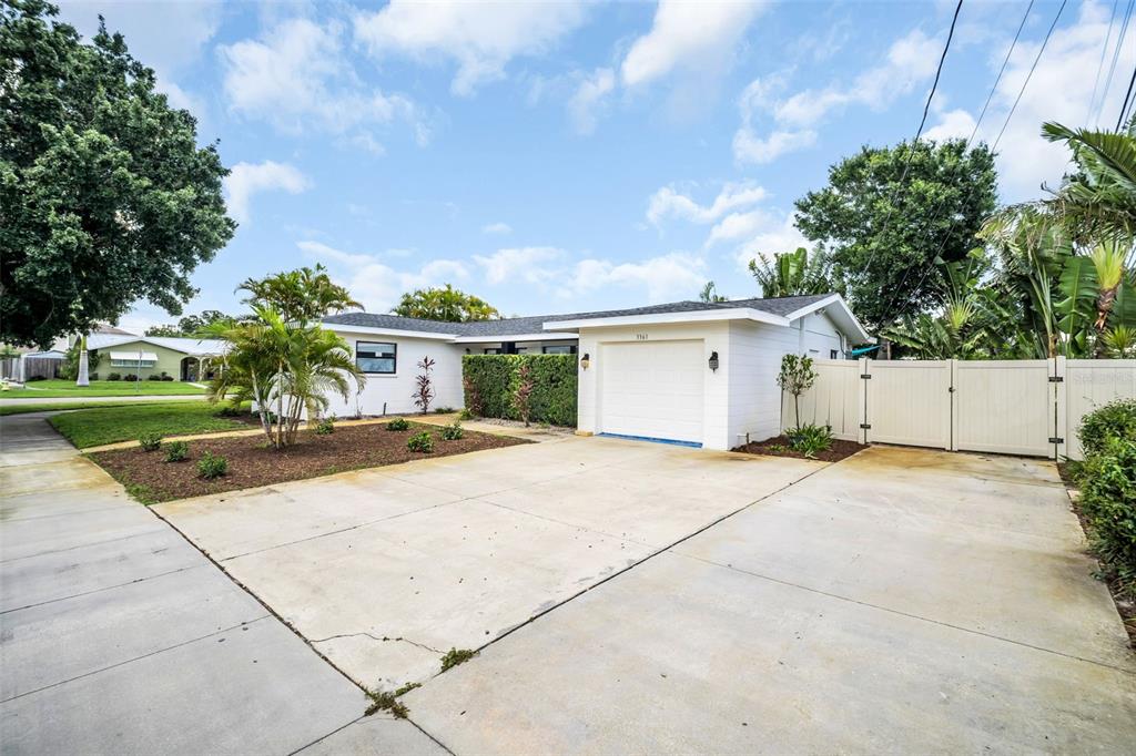 A single-story house with a white exterior, a one-car garage, and a concrete driveway — 3361 59TH STREET N, ST PETERSBURG, FL