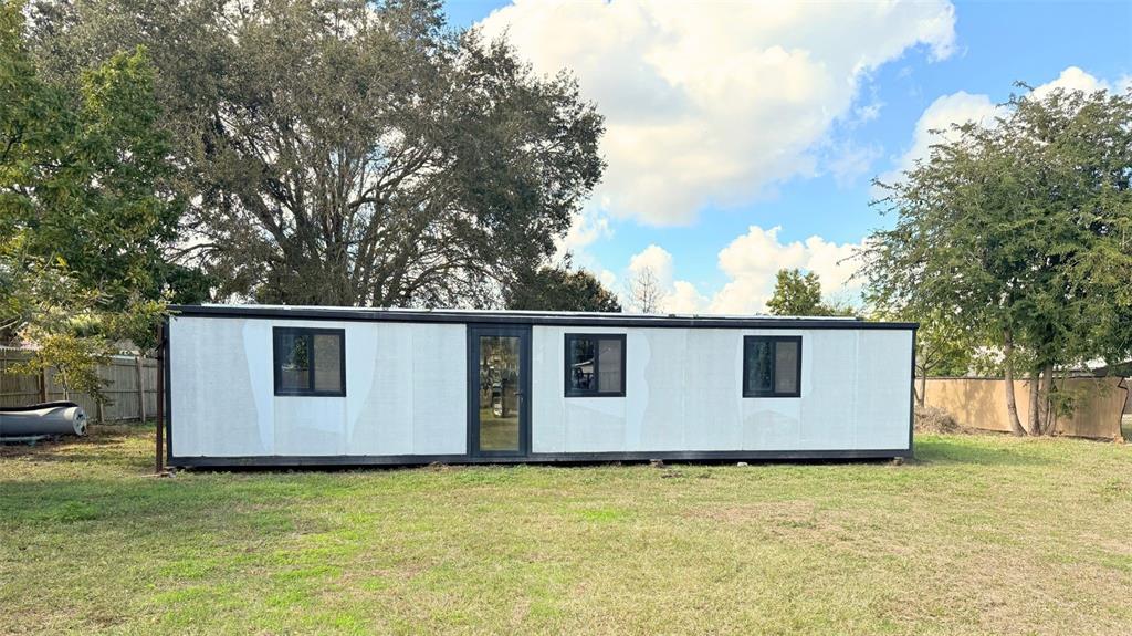 A rectangular, white modular structure with black-framed windows and a central glass door — 9560 HOENSTINE AVENUE, ORLANDO, FL