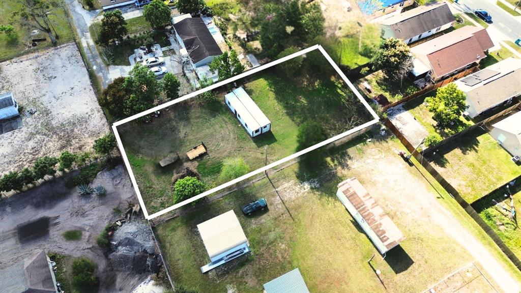 An aerial view shows a rectangular lot containing a single-story mobile home and trailer — 9560 HOENSTINE AVENUE, ORLANDO, FL