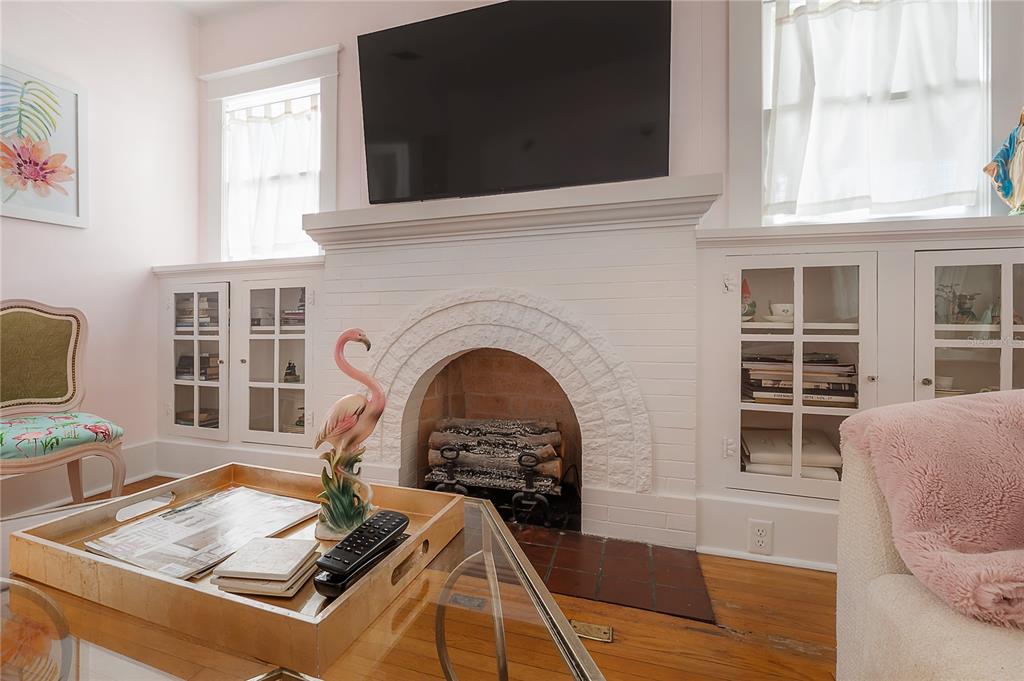 A living room features a white brick fireplace, built-in cabinets, and a glass coffee table — 2808 W AQUILLA STREET, TAMPA, FL
