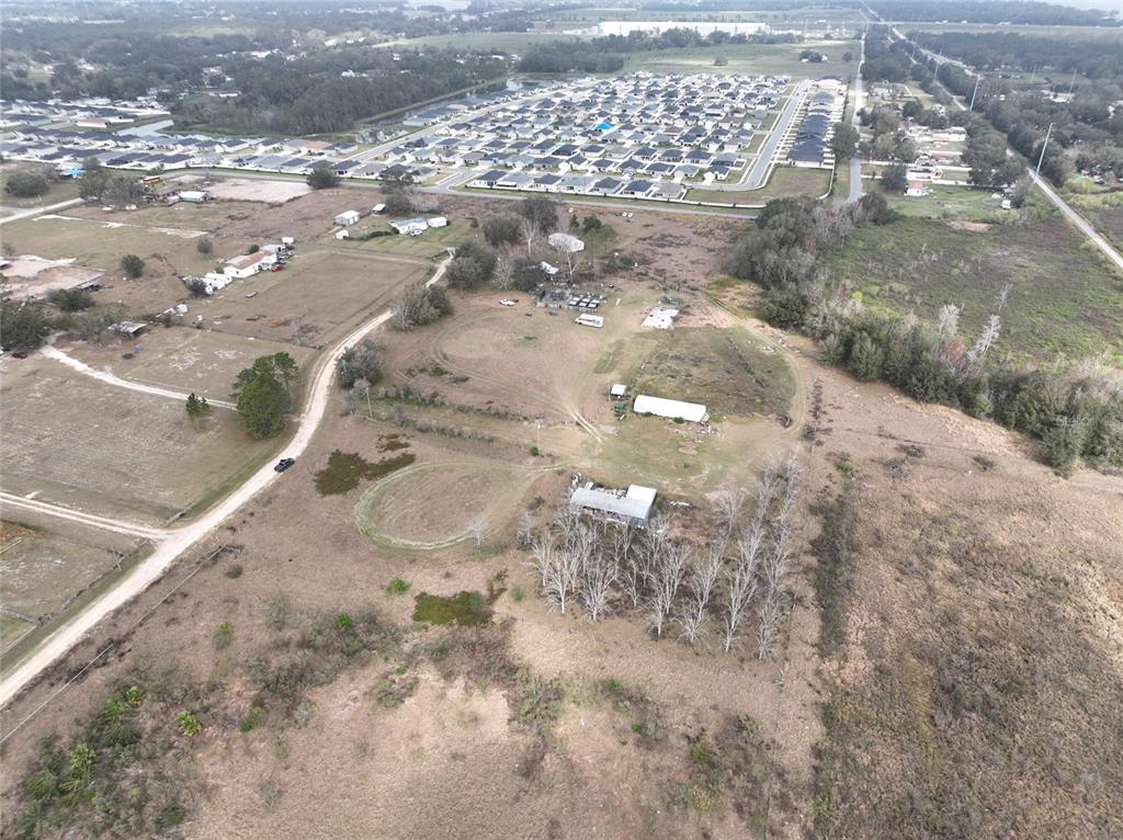 An aerial view shows a rural property with several buildings and a nearby housing development — 307 & 317 SKYBLUE LANE, AUBURNDALE, FL