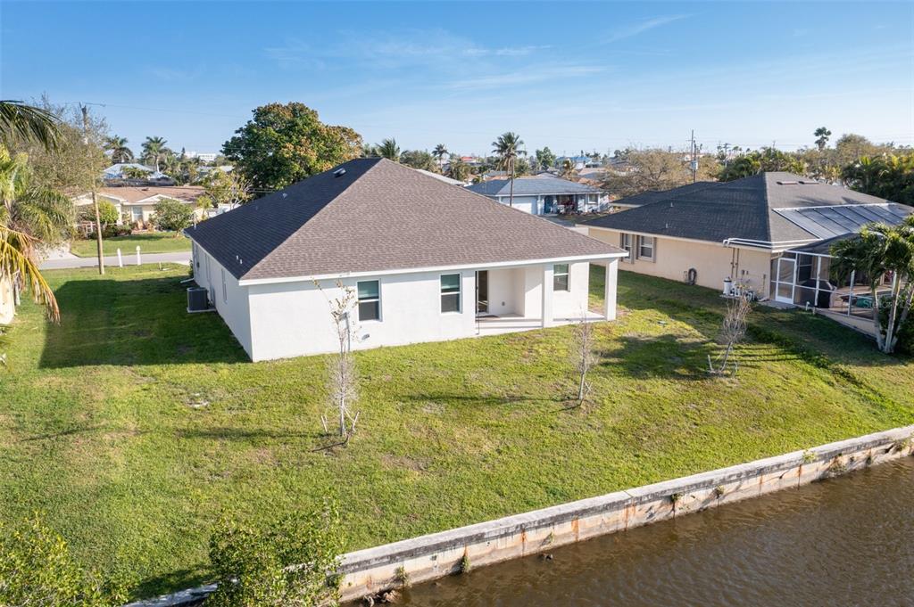 An aerial view of a white house with a brown roof situated along a canal — 1452 SE 13TH TERRACE, CAPE CORAL, FL