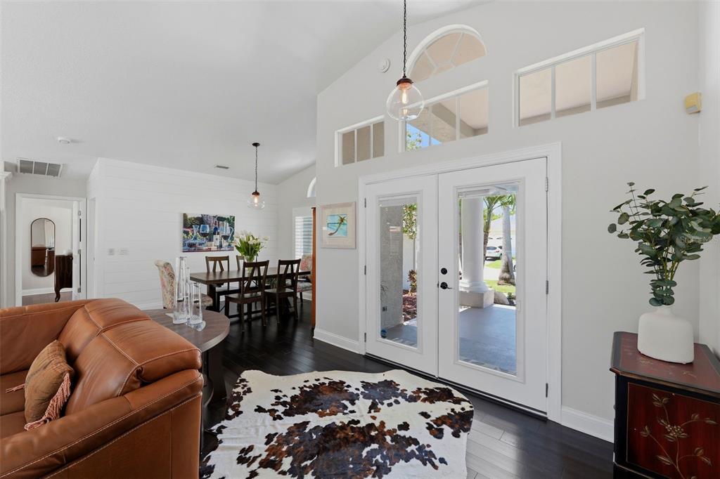 A covered front porch features two white rocking chairs and a small table — 631 DE SOTO DRIVE, TIERRA VERDE, FL